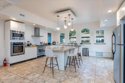 a kitchen with a large island with bar stools at Vista Haven with stunning views/hot tub/mini golf in Oakhurst