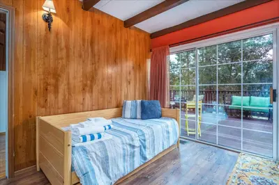 a bedroom with a bed and a large window at Bass Lake Chalet- A frame with hot tub/firepit in Oakhurst