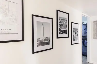 a row of framed photographs on a wall at Homey Pool Fun Gameroom Sunnyside Retreat in Fresno