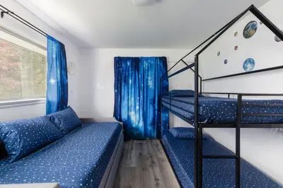 a room with two bunk beds and a staircase at Homey Pool Fun Gameroom Sunnyside Retreat in Fresno