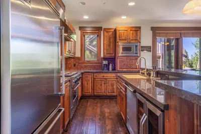 a kitchen with wooden cabinets and stainless steel appliances at Luxury Northstar Home Walk to Lifts Private Hot-Tub Fenced-In Yard Book on Mobile for Promo Price in Truckee