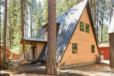 a cabin in the woods with a metal roof at Brand New Modern A-Frame In Kings Beach Two Blocks From The Beach in Kings Beach