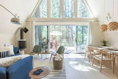 a living room with a blue couch and a table at Brand New Modern A-Frame In Kings Beach Two Blocks From The Beach in Kings Beach