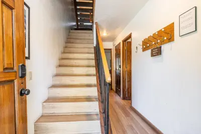 a staircase in a house with wooden floors at Snowflower #79 - Updated 2 Bedroom & Loft, 3 Bath, Sleeps 8, Steps away from Free Town Shuttle in Mammoth Lakes