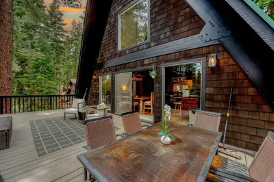 a wooden deck with a table and chairs on a house at 5BR A Frame Near Patton Beach with 2 Decks in Carnelian Bay