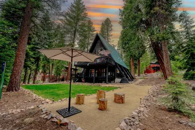 a large umbrella in front of a log cabin at 5BR A Frame Near Patton Beach with 2 Decks in Carnelian Bay