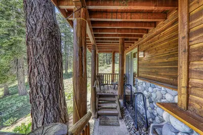 a porch of a log cabin with a tree at Horizon at Tahoe Donner w Private Hot Tub and Mountain Views in Truckee