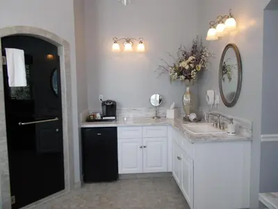 a white bathroom with a sink and a vase of flowers at The Inn at 161 in Sutter Creek