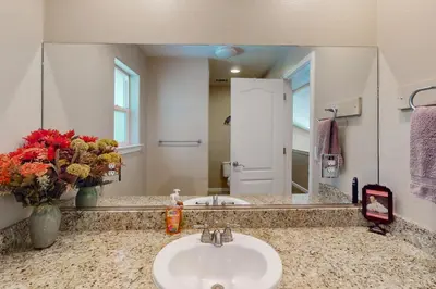 a bathroom with a sink and a large mirror at Creekside & Cozy in Bass Lake