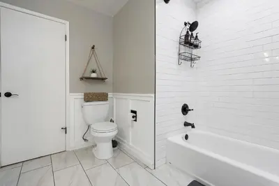 a white bathroom with a toilet and a bath tub at Home in the Pines - Apple Hill - Dog Friendly - Snow Nearby in Pollock Pines