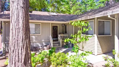 a house with a porch with a tree at Home in the Pines - Apple Hill - Dog Friendly - Snow Nearby in Pollock Pines