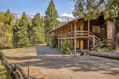 a log cabin with a driveway leading up to it at Big Pine Suite CN Lodge R#1 in Ponderosa
