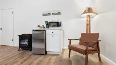 a living room with a chair and a microwave at Suite Meadow @CN Lodge# 7 in Ponderosa