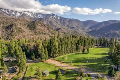 an aerial view of a green field in the mountains at Timberline Retreat CN Lodge #3 in Ponderosa