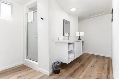 a bathroom with white walls and a mirror and wood floors at Timberline Retreat CN Lodge #3 in Ponderosa