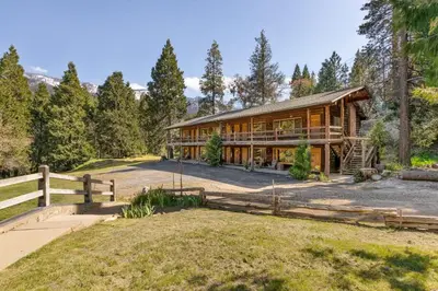 a home in the woods with a fence at Mountain Nook CN Lodge #4 in Ponderosa