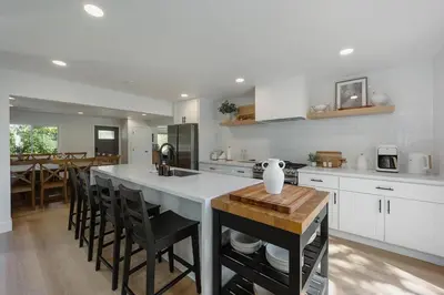 a kitchen with a large white counter top and a table at Lakefront Cottage at Lakewood in Auburn