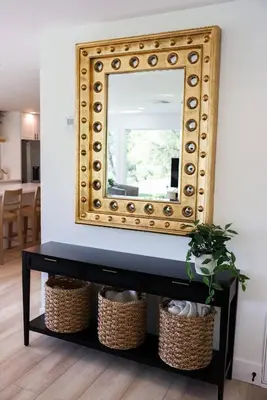 a mirror on a black console table with baskets at Treehouse Overlook at Lakewood in Auburn
