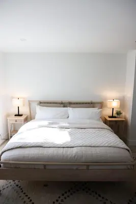 a bedroom with a large bed with two lamps on tables at Treehouse Overlook at Lakewood in Auburn