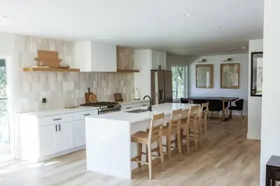 a kitchen with white cabinets and a table with chairs at Treehouse Overlook at Lakewood in Auburn
