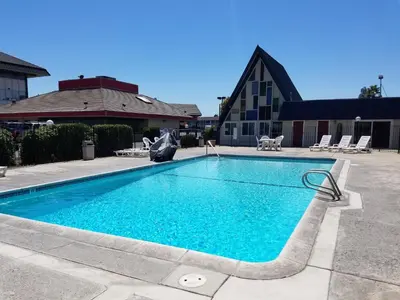 a swimming pool with blue water in a yard at Economy Inn Fresno Yosemite in Fresno