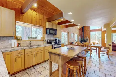 a kitchen with wooden cabinets and a table and chairs at Summit Sanctuary in Stateline