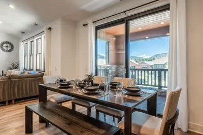 a dining room with a table and chairs and a large window at Creekhouse 1353 in Mammoth Lakes