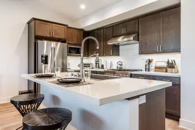 a kitchen with wooden cabinets and a kitchen island with stools at Creekhouse 1353 in Mammoth Lakes