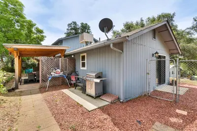 a building with a grill in the yard at Yosemite Wellbeing Retreat on 5 Acres with Mtn Views in Ahwahnee