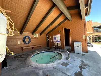 a building with a hot tub in front of it at Sunrise #33 condo in Mammoth Lakes