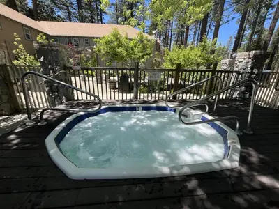 a hot tub in a yard with a fence at Camp Richardson Resort in South Lake Tahoe