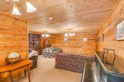 a log cabin with a living room and a bedroom at Game Room and Hot Tub Serene Grand Mountain Chalet! in Stateline