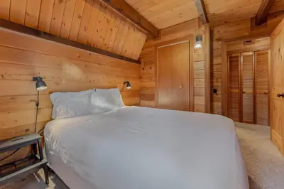 a bedroom with a bed in a wooden cabin at 3BR with Sauna & Lake Views, 2 miles to Beach in Tahoe City
