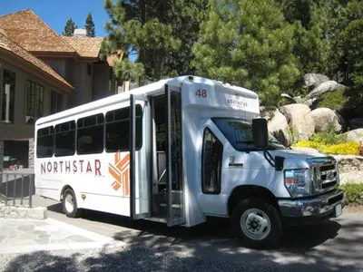 a white bus parked in front of a house at Elevation Ski-in, Ski-out in Northstar w Private Hot Tub & HOA Amenities in Truckee
