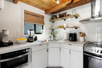 a white kitchen with white cabinets and a window at Lake Isabella A frames in Lake Isabella