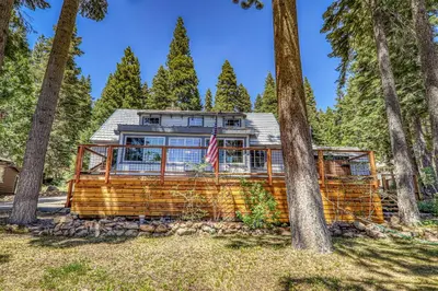 a log home in the woods with trees at Reflections Lakeview Cabin - Private Beach Access, Hot Tub & Buoy! in Carnelian Bay