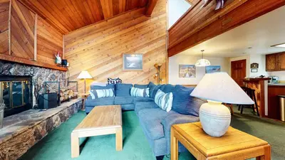 a living room with a blue couch and a fireplace at Mammoth Sierra Townhomes #23 condo in Mammoth Lakes