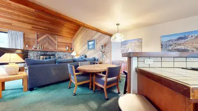 a living room with a table and a couch at Mammoth Sierra Townhomes #23 condo in Mammoth Lakes