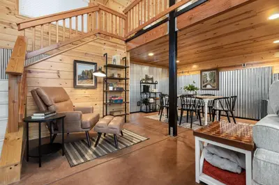 a living room with a table and chairs in a cabin at The Pine Loft | Yosemite in North Fork