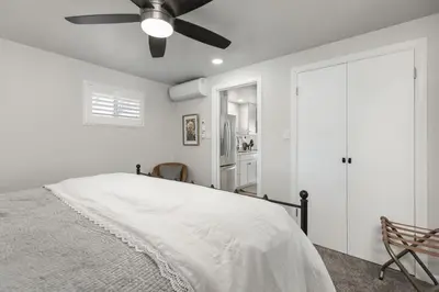 a white bedroom with a bed and a ceiling fan at Mountain View Apartment in North Fork