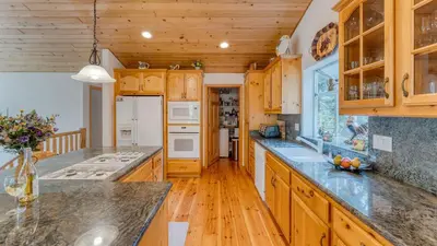 a kitchen with wooden cabinets and granite counter tops at Tahoe Vista by AvantStay Central Location Patio in Tahoe Vista