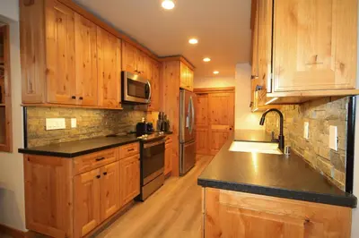 a kitchen with wooden cabinets and a black counter top at Tamarack 39 in Mammoth Lakes