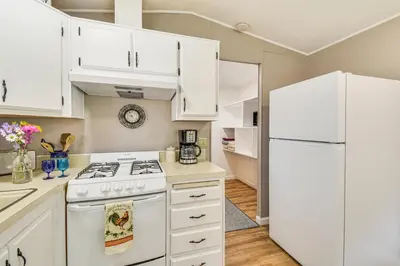 a kitchen with white cabinets and a white refrigerator at La Grange Home with Covered Patio and Gas Grill! in La Grange