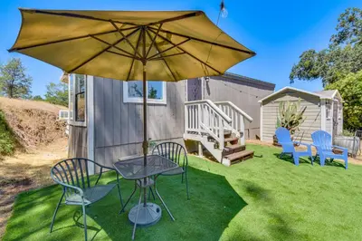 a patio with a table and chairs and an umbrella at La Grange Home with Covered Patio and Gas Grill! in La Grange