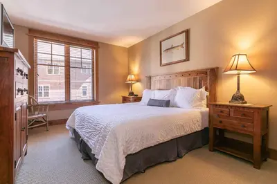a bedroom with a large bed and a window at Big Horn Lodge 301 by East West Hospitality in Truckee