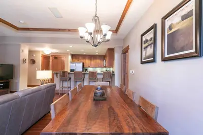 a dining room and living room with a wooden table at Big Horn Lodge 301 by East West Hospitality in Truckee