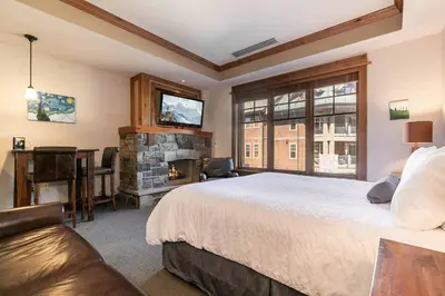 a bedroom with a large bed and a fireplace at Big Horn Lodge 305 by East West Hospitality in Truckee