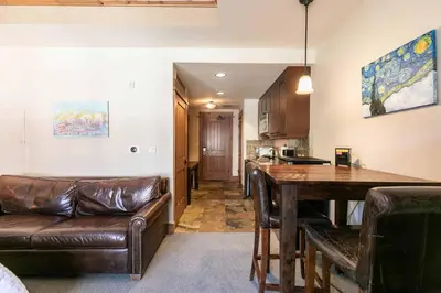 a living room with a leather couch and a table at Big Horn Lodge 305 by East West Hospitality in Truckee