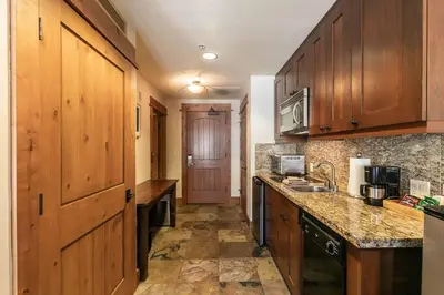 a kitchen with wooden cabinets and a counter top at Big Horn Lodge 305 by East West Hospitality in Truckee