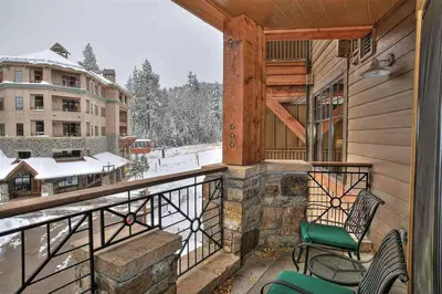 a balcony with a chair and a snow covered yard at Big Horn Lodge 309 by East West Hospitality in Truckee